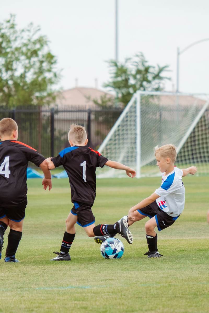 Crianças jogando futebol no gramado da escola