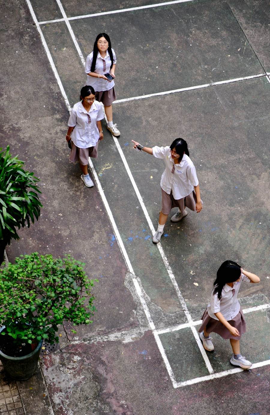 Crianças de uniforme escolar brincando no pátio, vistas de cima