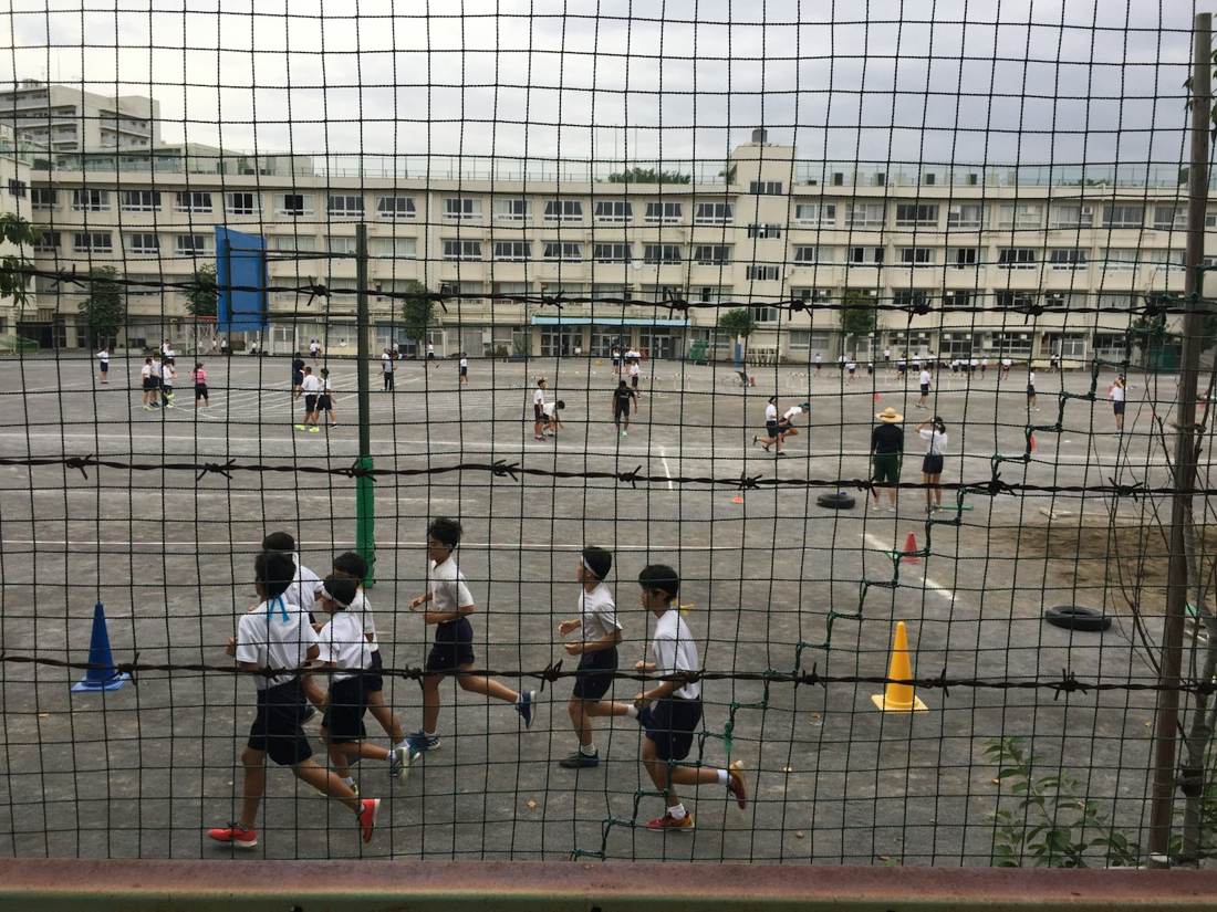 Recreio com crianças correndo na quadra da escola
